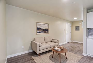 Seattle apartment for rent - A living room with a beige couch, a coffee table, and a painting on the wall.