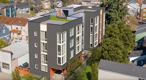 Seattle apartment for rent - A modern building with a green roof is surrounded by other buildings.