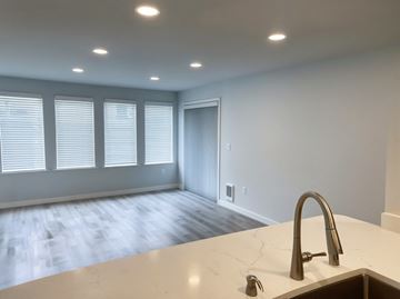 Seattle apartment for rent - A kitchen counter with a sink and a window with blinds.