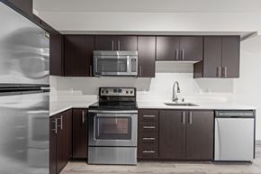 Seattle apartment for rent - A modern kitchen with dark brown cabinets and stainless steel appliances.