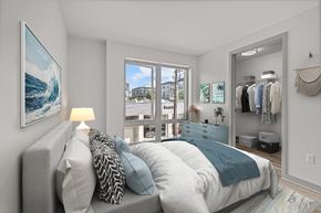 Seattle apartment for rent - A bedroom with a large bed and a painting of a wave on the wall.