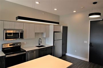 Lincoln apartment for rent - a kitchen with black and white cabinets and stainless steel appliances