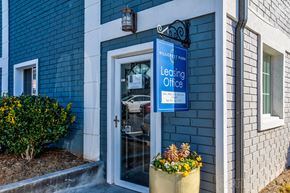 Atlanta apartment for rent - a blue building with a leasing office sign and a glass door