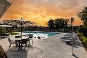 Stone Mountain townhouse for rent - a swimming pool with chairs and umbrellas at sunset