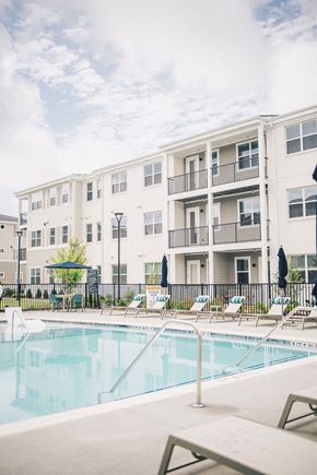 Mcdonough apartment for rent - a swimming pool in front of an apartment building at Woodlands Creekside Apartments, McDonough, GA, 30253