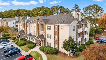 Alpharetta apartment for rent - A large apartment complex with a parking lot in front.