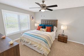 Dunwoody apartment for rent - A bedroom with a bed, a ceiling fan, and two lamps.