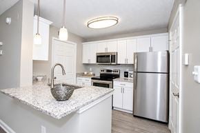 Dunwoody apartment for rent - A kitchen with a granite countertop and stainless steel appliances.