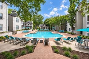 Dunwoody apartment for rent - A swimming pool surrounded by lounge chairs and trees.
