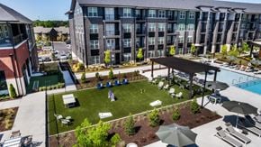Duluth townhouse for rent - A large outdoor swimming pool area with a grassy area and a pavilion.