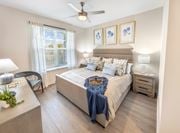 Dacula townhouse for rent - A bedroom with a bed, nightstand, and chair.