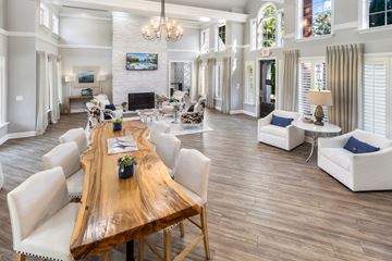 Brentwood apartment for rent - A large, well-lit living room with a wooden dining table and white chairs.