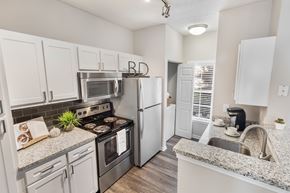 Brentwood apartment for rent - A kitchen with white cabinets and a granite countertop. at The Estates at Brentwood, Brentwood, TN, 37027