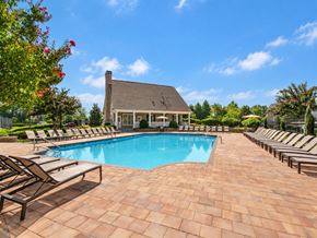 Grayson apartment for rent - A pool surrounded by lounge chairs and a house in the background.