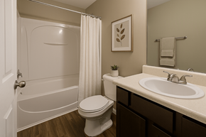 Lilburn apartment for rent - A white toilet sits next to a white sink in a bathroom.