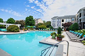 Alpharetta townhouse for rent - A large swimming pool surrounded by lounge chairs and potted plants.