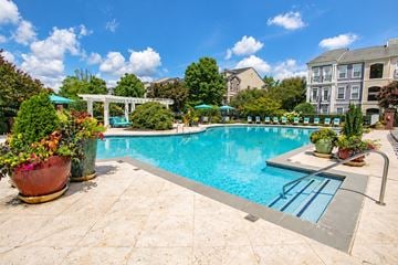 Alpharetta townhouse for rent - A pool surrounded by a patio and a garden.