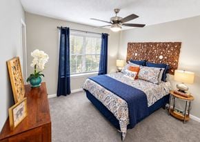 Dunwoody apartment for rent - A bedroom with a bed, a ceiling fan, and a nightstand with a lamp.