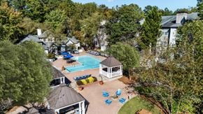 Dunwoody apartment for rent - A pool surrounded by trees and a gazebo at The Point at Perimeter, Georgia, 30338