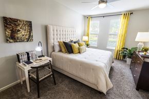 Duluth apartment for rent - a bedroom with a white bed and yellow curtains