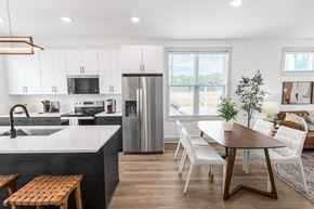 Atlanta townhouse for rent - a kitchen and dining room with white cabinets and a stainless steel refrigerator