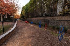 Duluth apartment for rent - a path in a park with playground equipment and a fence at The Reserve at Sugarloaf Apartments, Duluth, GA, 30097