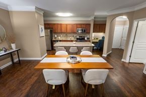 Duluth apartment for rent - a dining room and kitchen with a wooden table and chairs at The Reserve at Sugarloaf Apartments, Georgia