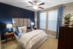 Duluth apartment for rent - a bedroom with a large bed and a ceiling fan at The Reserve at Sugarloaf Apartments, Duluth, GA