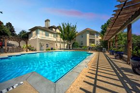 Atlanta apartment for rent - A large swimming pool in front of a house with a wooden pergola.
