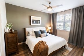 Mcdonough apartment for rent - a bedroom with a large white bed and a ceiling fan at Woodlands Creekside Apartments, Georgia