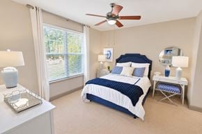 Charlotte apartment for rent - A bedroom with a bed, nightstand, and window.