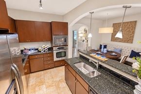 Charlotte apartment for rent - A kitchen with a refrigerator, microwave, oven, sink, and a table with chairs.