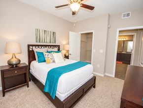 Alpharetta apartment for rent - A bedroom with a bed, nightstand, and a ceiling fan.