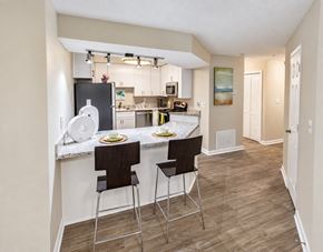 Alpharetta apartment for rent - A kitchen with a bar area and two chairs.