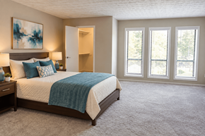 Alpharetta apartment for rent - A bedroom with a large bed and a painting on the wall.