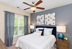 Fort Mill apartment for rent - A bedroom with a white bed and a ceiling fan.