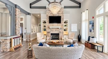 Fort Mill apartment for rent - A living room with a grey couch and a stone fireplace.
