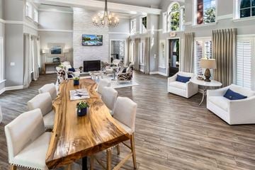Brentwood apartment for rent - A large, well-lit living room with a wooden table and white chairs.