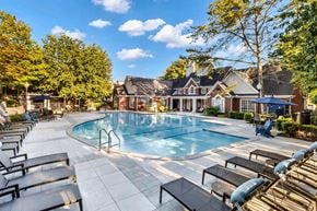 Brentwood apartment for rent - A large outdoor swimming pool surrounded by sun loungers and trees.