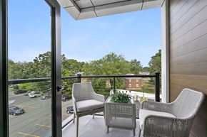 West Hartford apartment for rent - Two chairs on a balcony overlooking a parking lot and trees.