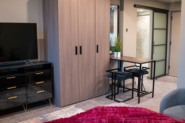 Hartford apartment for rent - A modern living room with a red rug and a black television.