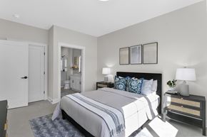 Rocky Hill apartment for rent - A bedroom with a large bed and a nightstand with a lamp.