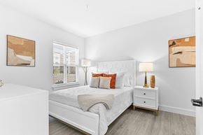 Newington apartment for rent - A white bedroom with a bed, nightstand, and two framed artworks on the wall.
