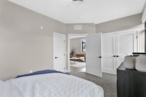 West Hartford apartment for rent - A bedroom with a large bed and a couch in the background.