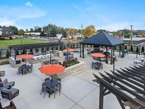 Newington apartment for rent - A gazebo with red umbrellas is surrounded by tables and chairs.