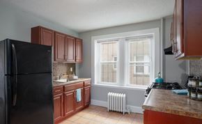 Hartford apartment for rent - A kitchen with brown cabinets and a black refrigerator.
