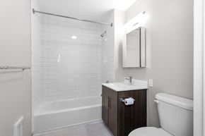 Bridgeport apartment for rent - a bathroom with a toilet sink and tub and a mirror  at 1188 Lofts, Bridgeport, Connecticut