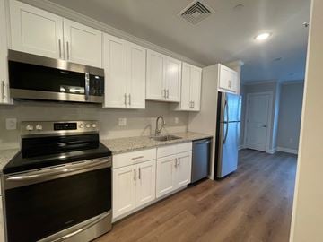 Brookfield apartment for rent - a kitchen with white cabinets and stainless steel appliances
