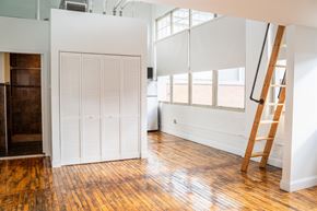 Hartford apartment for rent - A room with a wooden floor and a white wall with a ladder leaning against it.