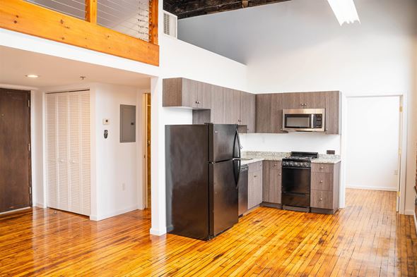 Hartford apartment for rent - A kitchen with a black fridge and wooden floors.